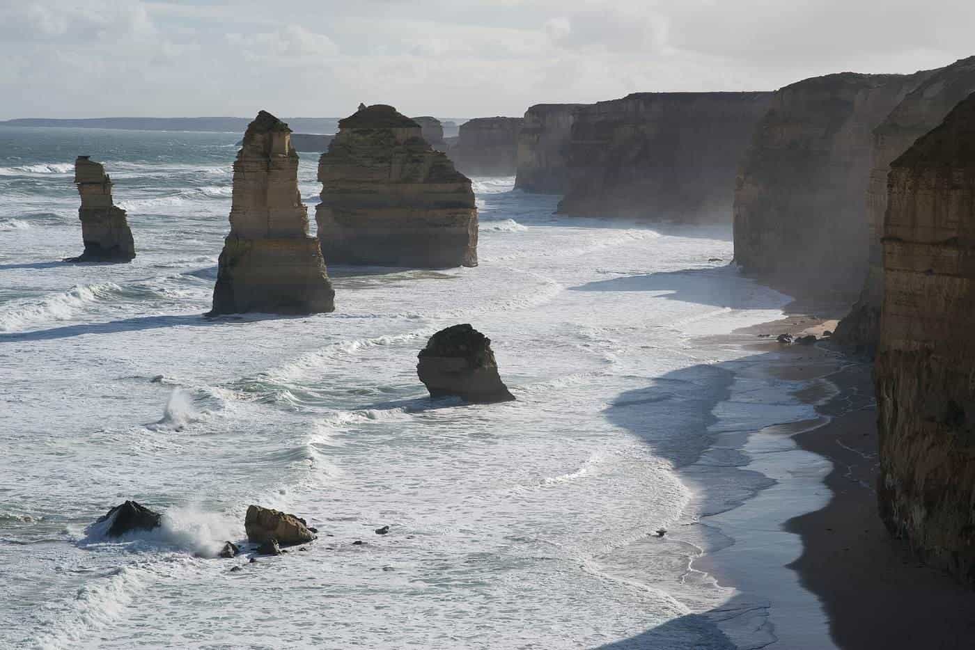 The Twelve Apostles limestone stacks along a rugged coastline at sunset